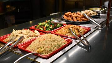 A buffet with various dishes including fried rice, vegetables, and spring rolls.
