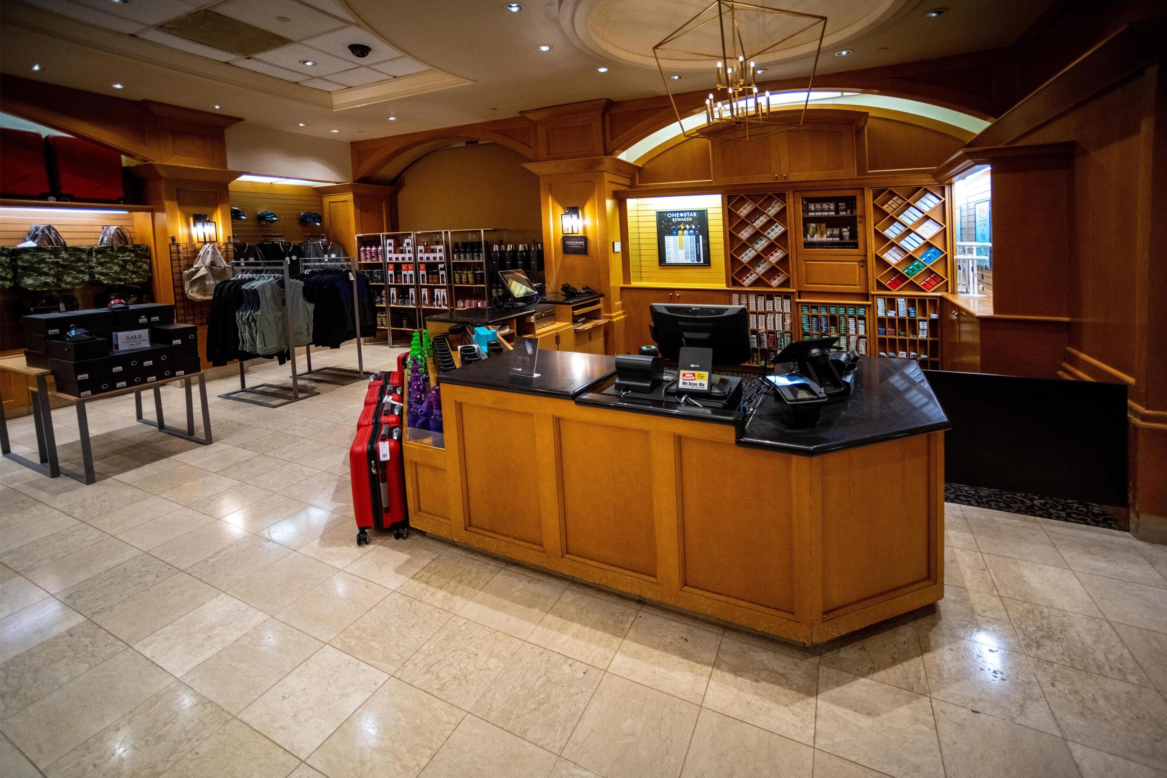 A hotel lobby with a reception desk, a shoe display, and a wine rack.