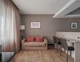 Un soggiorno moderno con un divano, un'area pranzo e una lampada.