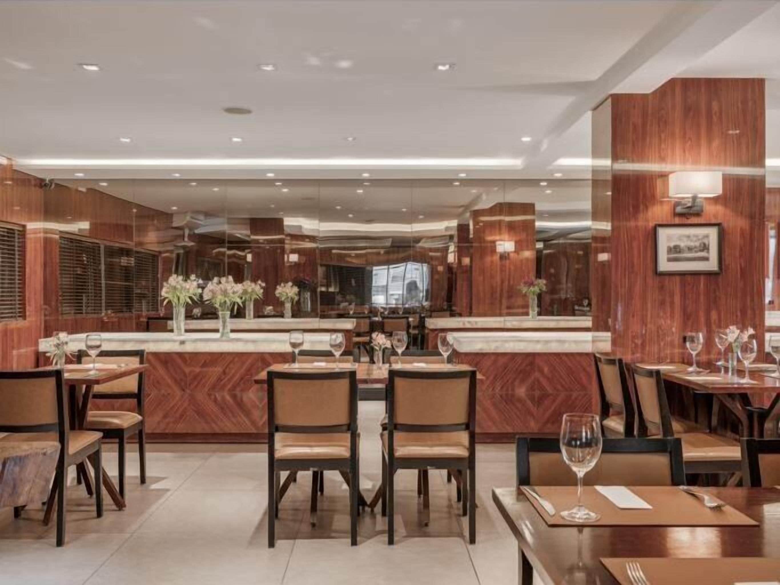 Un restaurante moderno con paneles de madera, varias mesas y sillas.