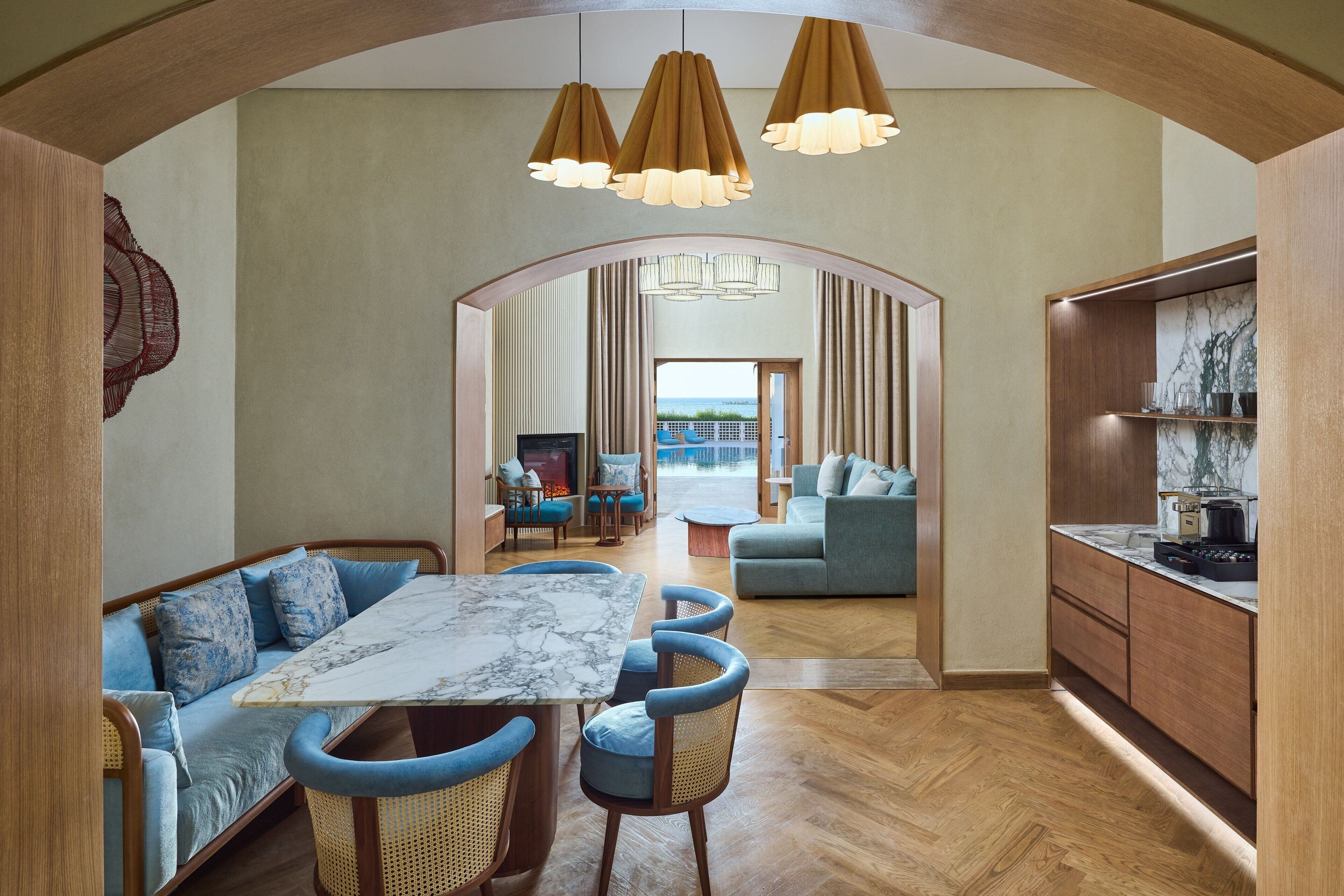 A modern interior with a dining area, sofa, and kitchen.