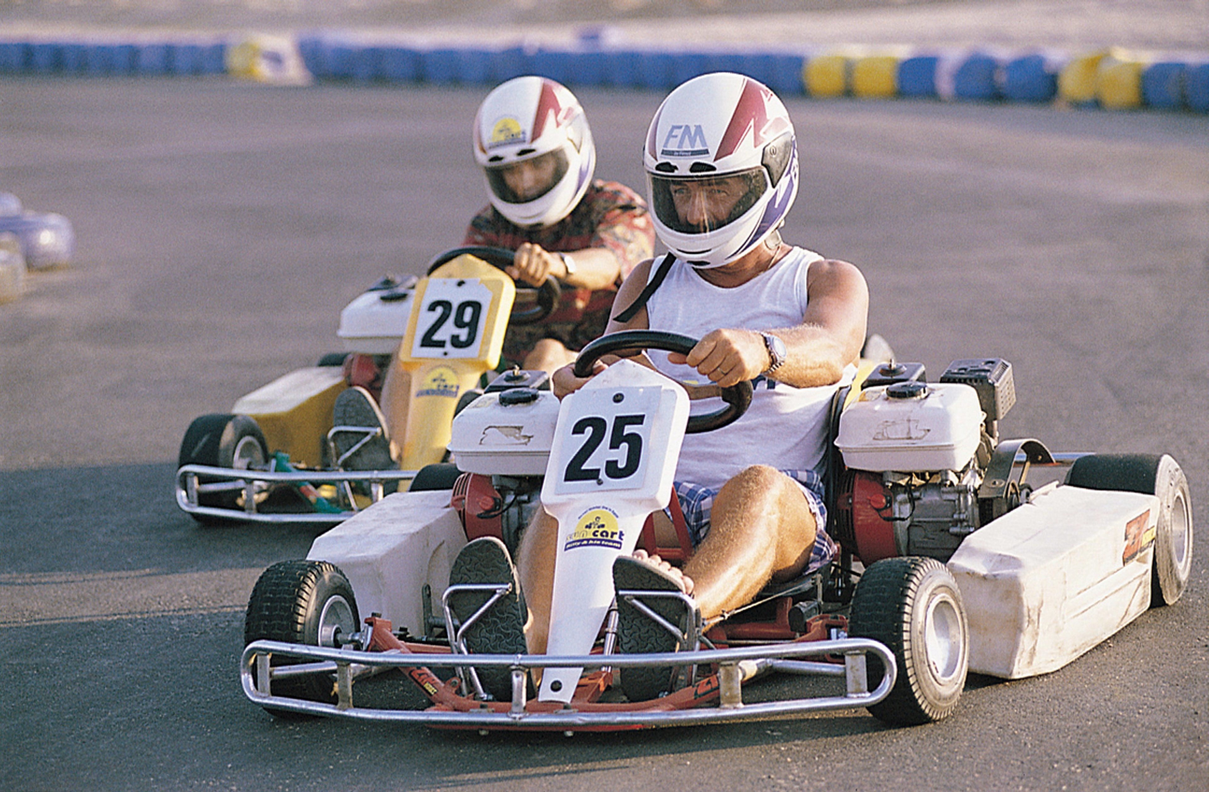 Dos karts de carreras con los números 25 y 29 compiten en una pista.