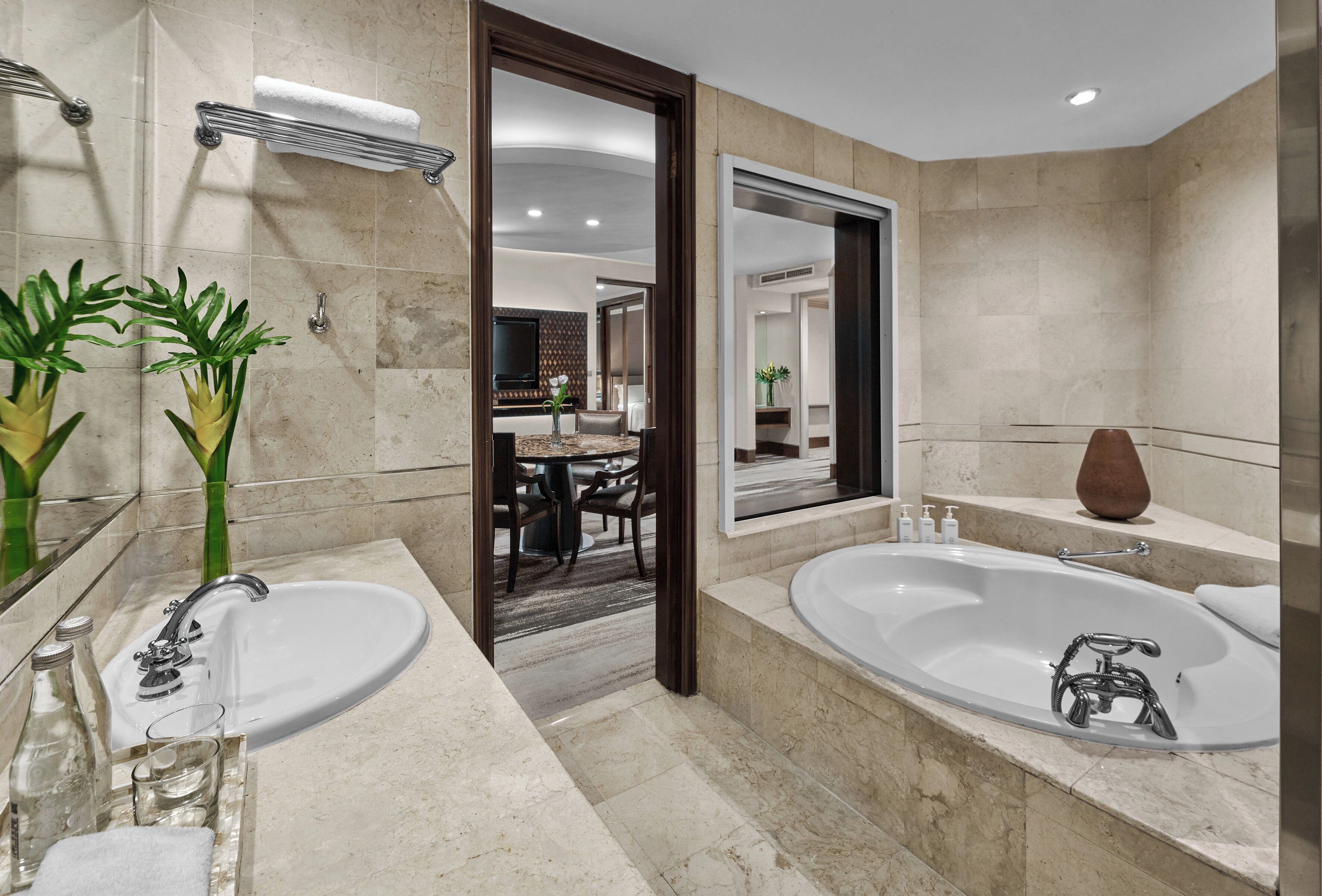 Un baño moderno con una bañera grande, un lavabo doble y un espejo.