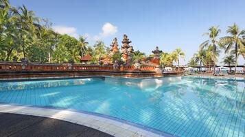 Alberca al aire libre, sombrillas en la alberca y camastros