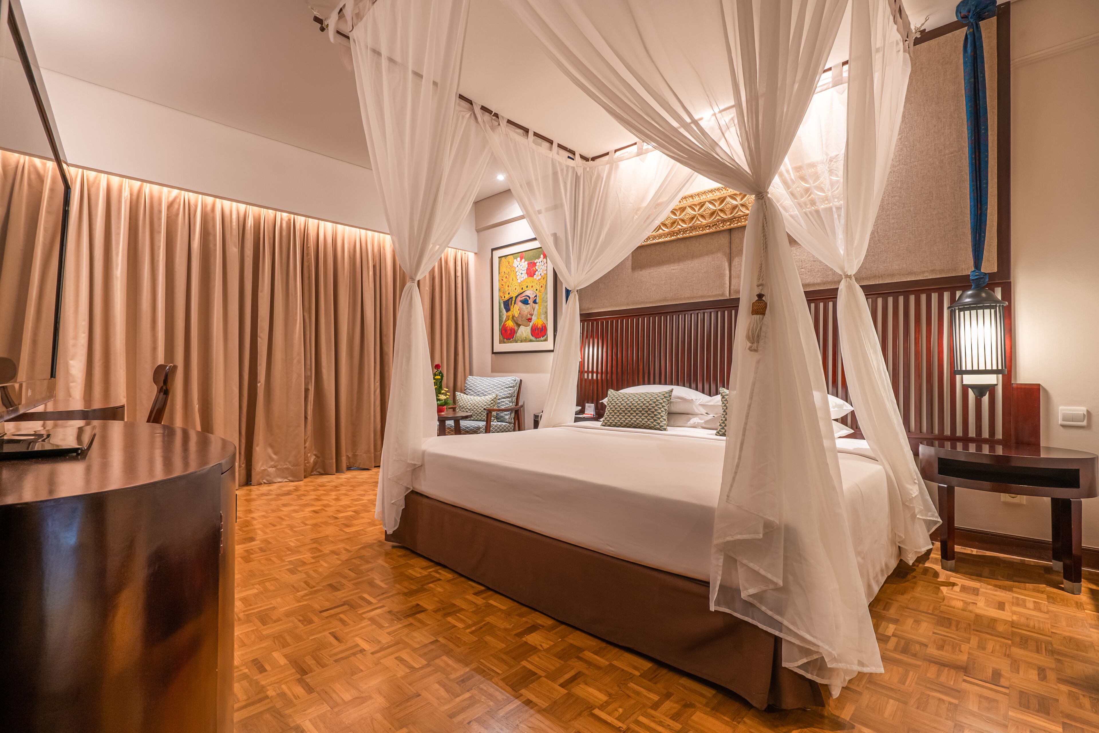 A bedroom with a bed under a canopy, a bedside table, a chair, and a desk.