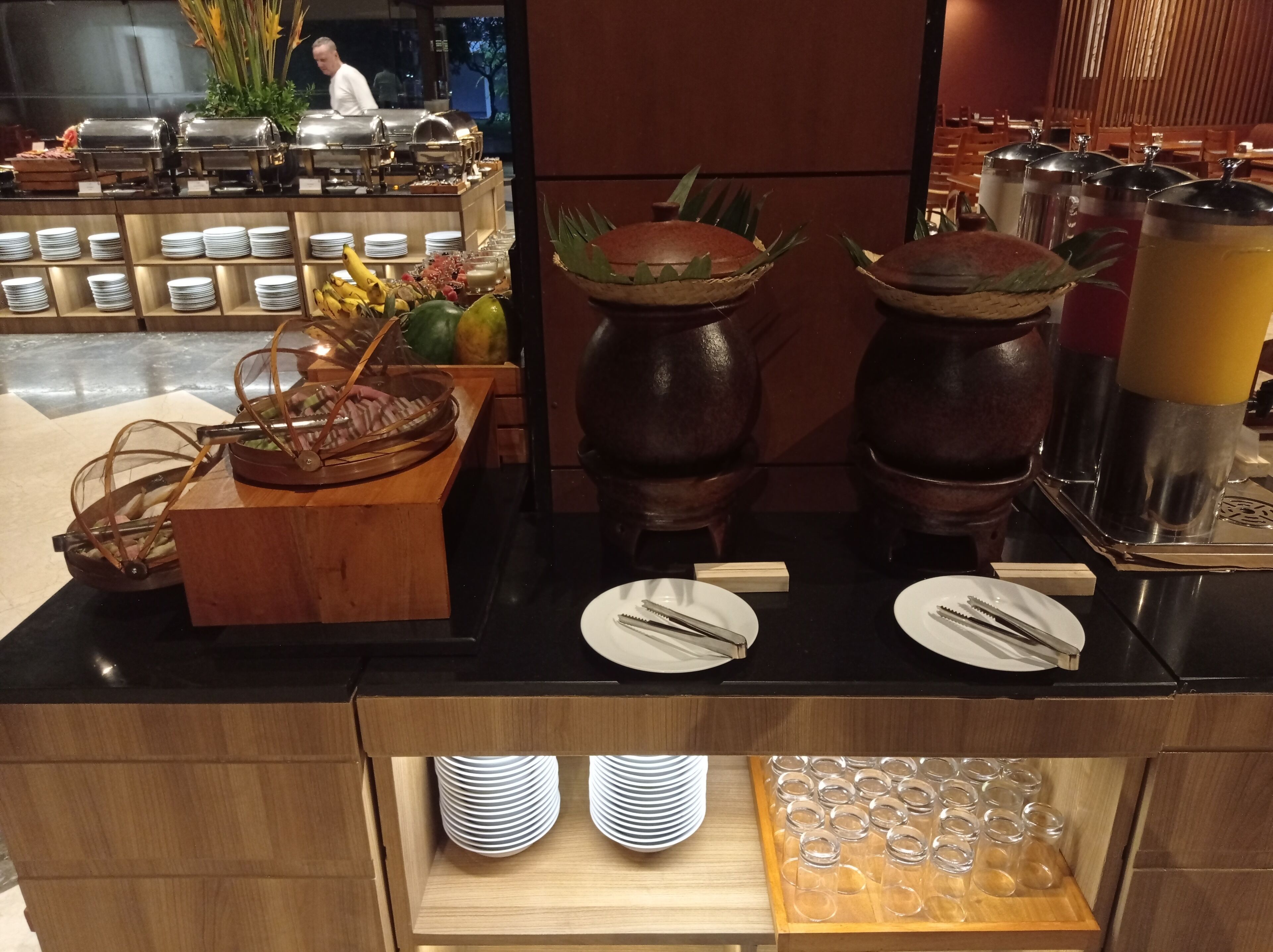 Een buffetopstelling met diverse gerechten, borden en bestek.