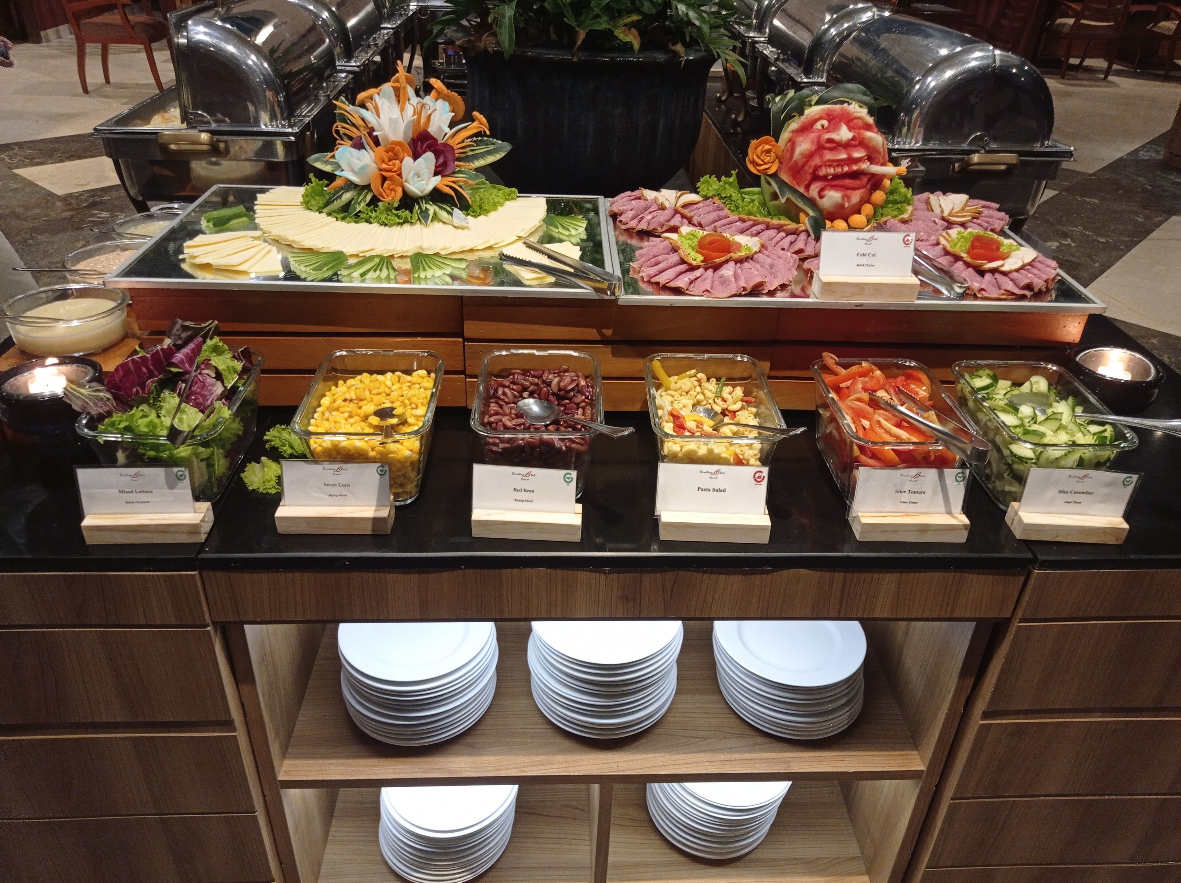 A buffet with various food options including salads, meats, and pasta.