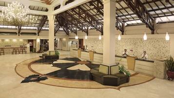 A spacious lobby with a high ceiling, a central seating area, and a reception desk.