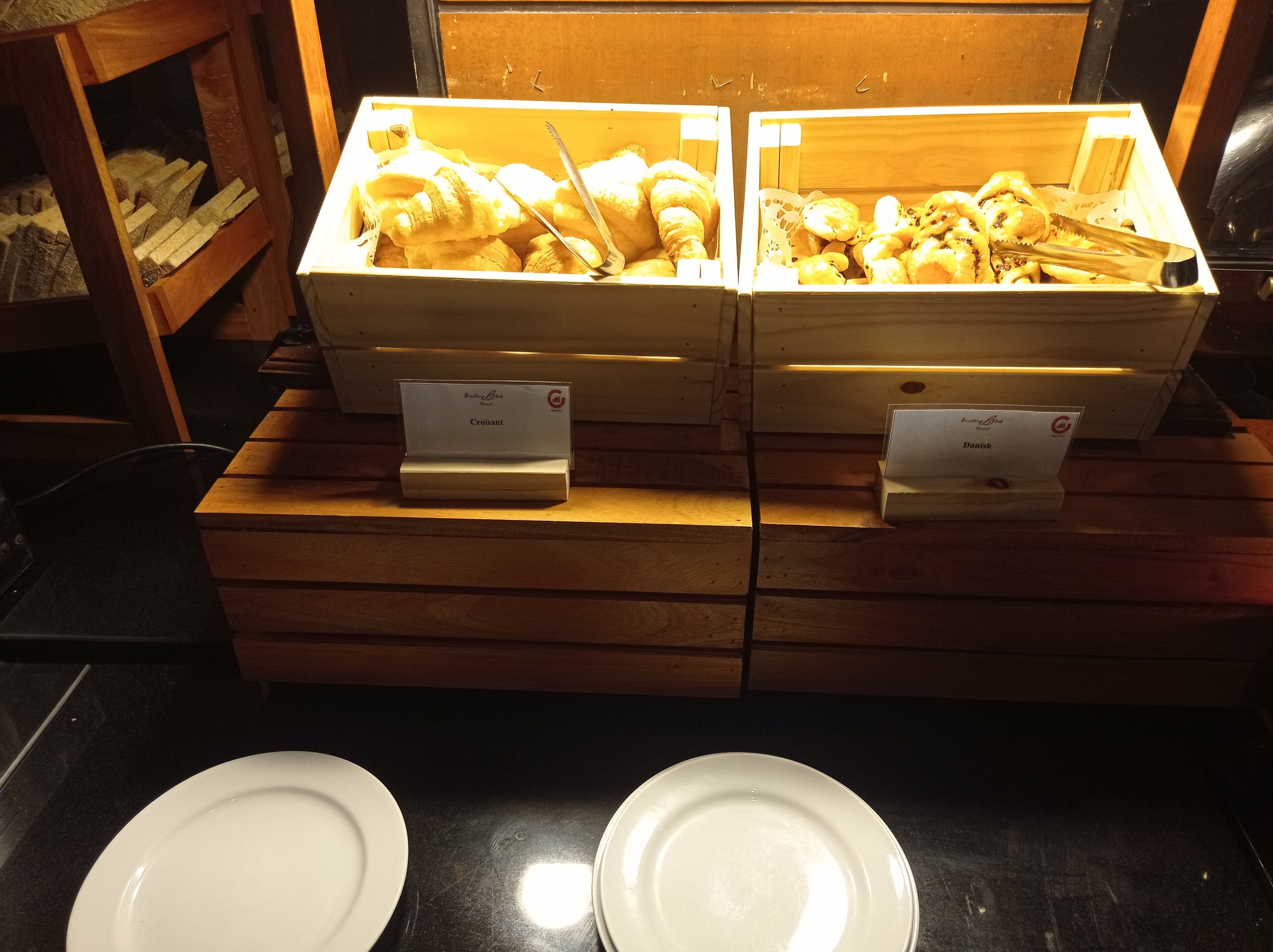A bakery display with two wooden boxes labeled "Croissant" and "Danish."