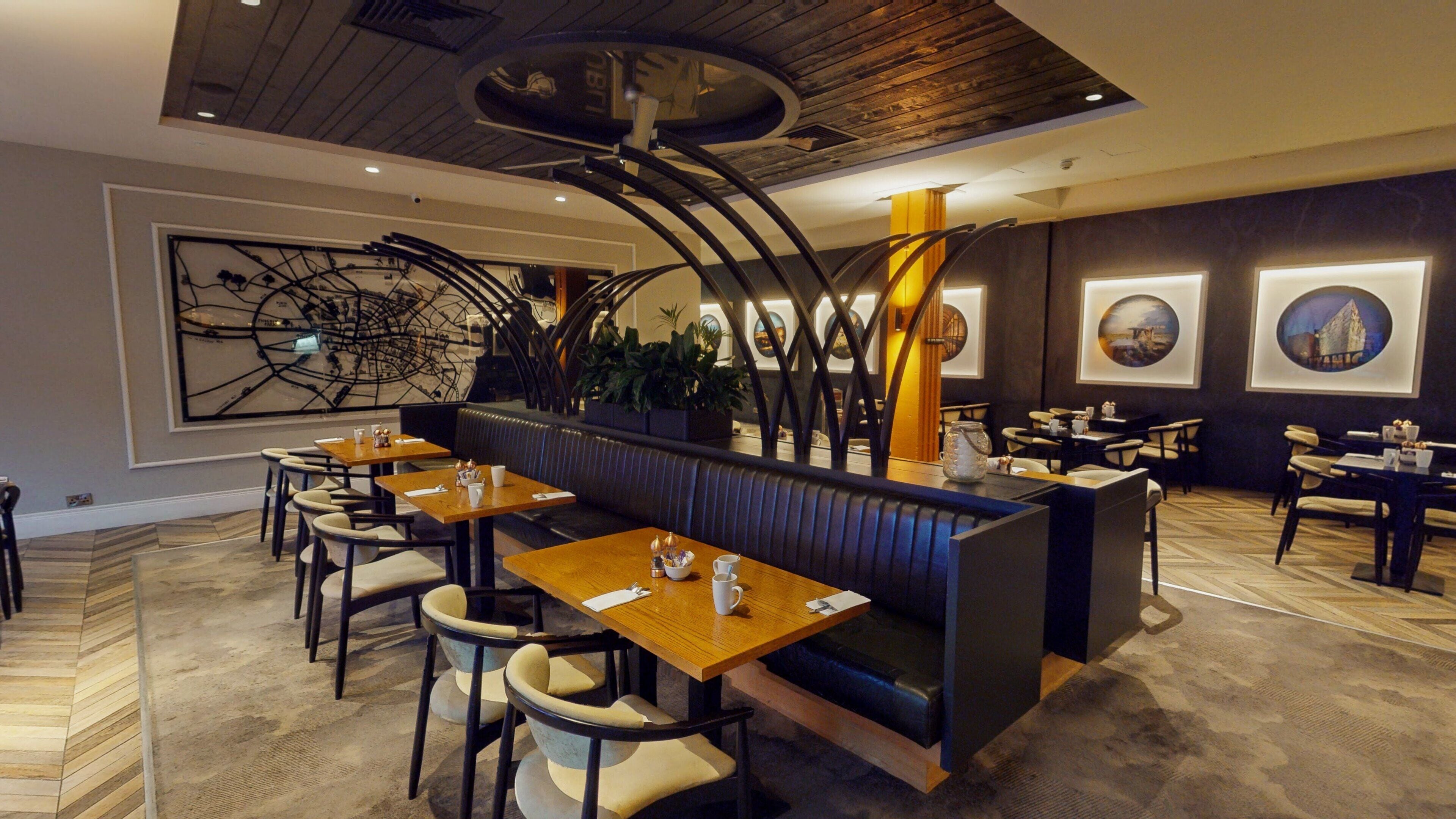 En restaurant med både båse og borde, et moderne loftdesign og kunst på væggene.