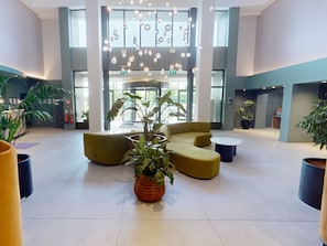 A modern lobby with a central seating area, large windows, and hanging light fixtures. - Clayton Hotel Dublin Airport Central (Corballis)