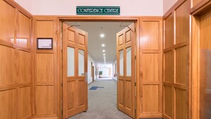 Um corredor com portas de madeira e uma placa indicando 