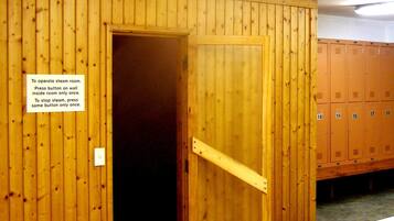 Uma sala de vapor com paredes de madeira e uma placa com instruções de uso.