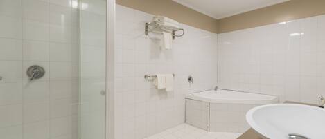 A modern bathroom with a glass shower enclosure, a freestanding bathtub, and a large oval sink.