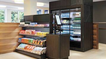 Een automaat voor zelfbediening met een digitaal scherm, gevuld met verschillende dranken en snacks.