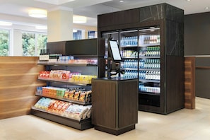 Un distributore automatico di bevande e snack, dotato di schermo digitale e fornito di una vasta scelta.