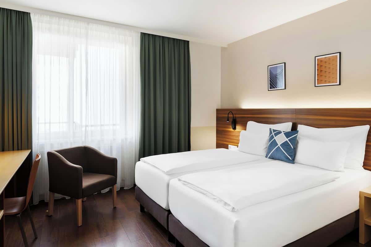 Una habitación de hotel con una cama grande, un escritorio y una silla.