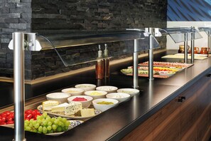 Een buffet met diverse gerechten en bijbehorende sauzen.