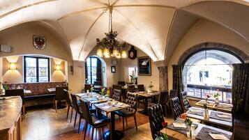 Interior de restaurant amb alts sostres apuntats, diverses taules i caires.