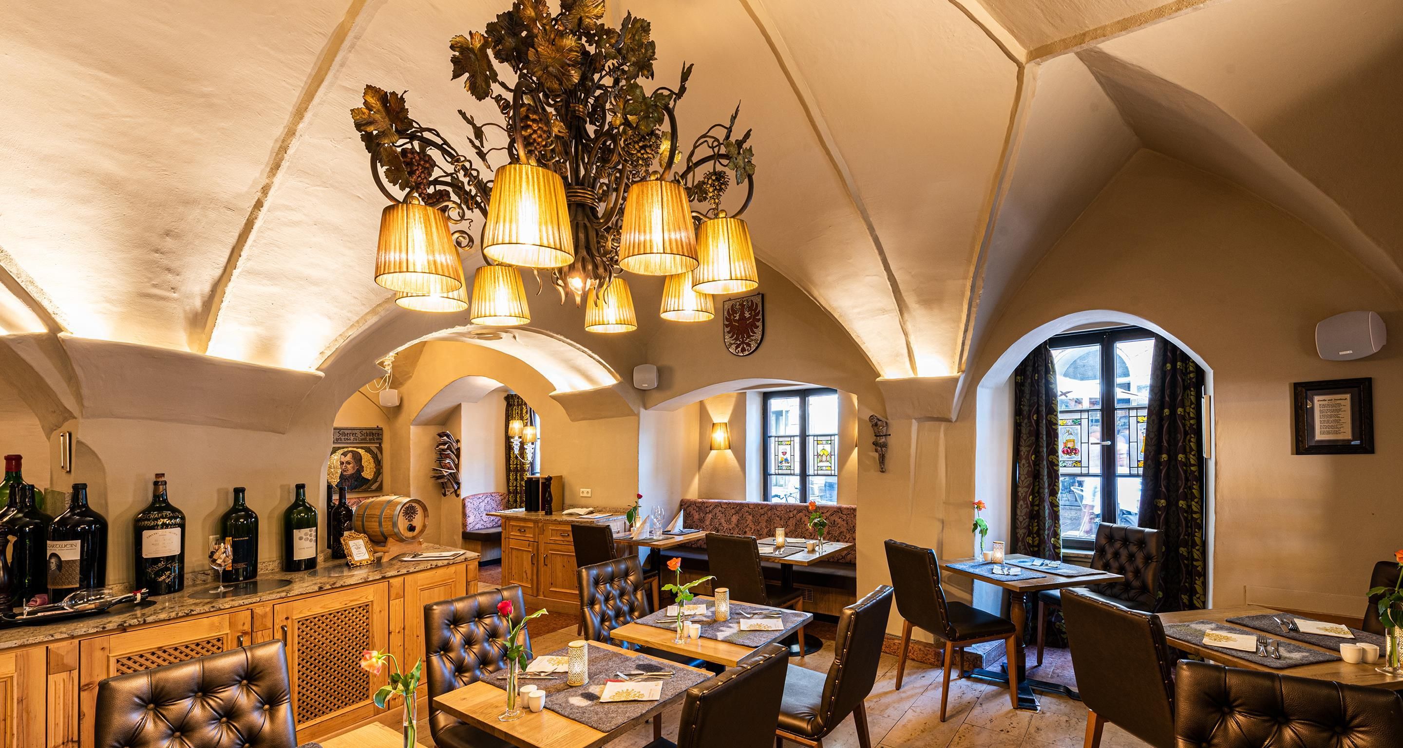 Ein Restaurant mit Barbereich, Holzmöbeln und einem Chandelier.