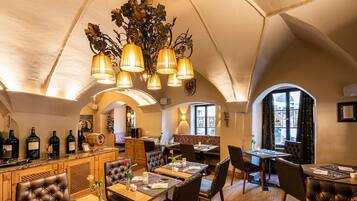 Ein Restaurant mit Barbereich, Holzmöbeln und einem Chandelier.