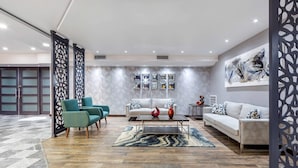 A modern living room with a sofa, two armchairs, a coffee table, and decorative vases.