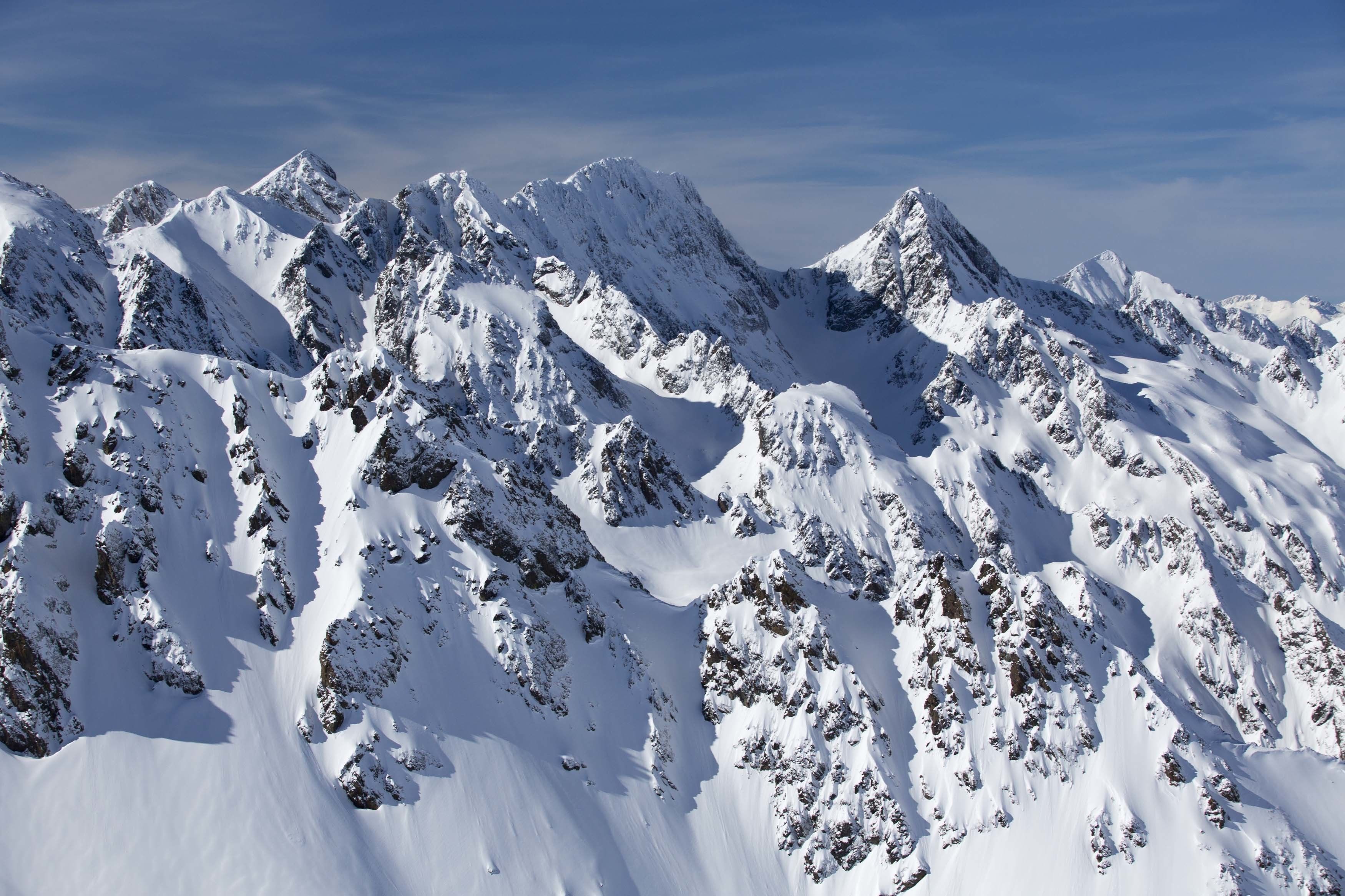 A snow-covered mountain range with rugged peaks and valleys.