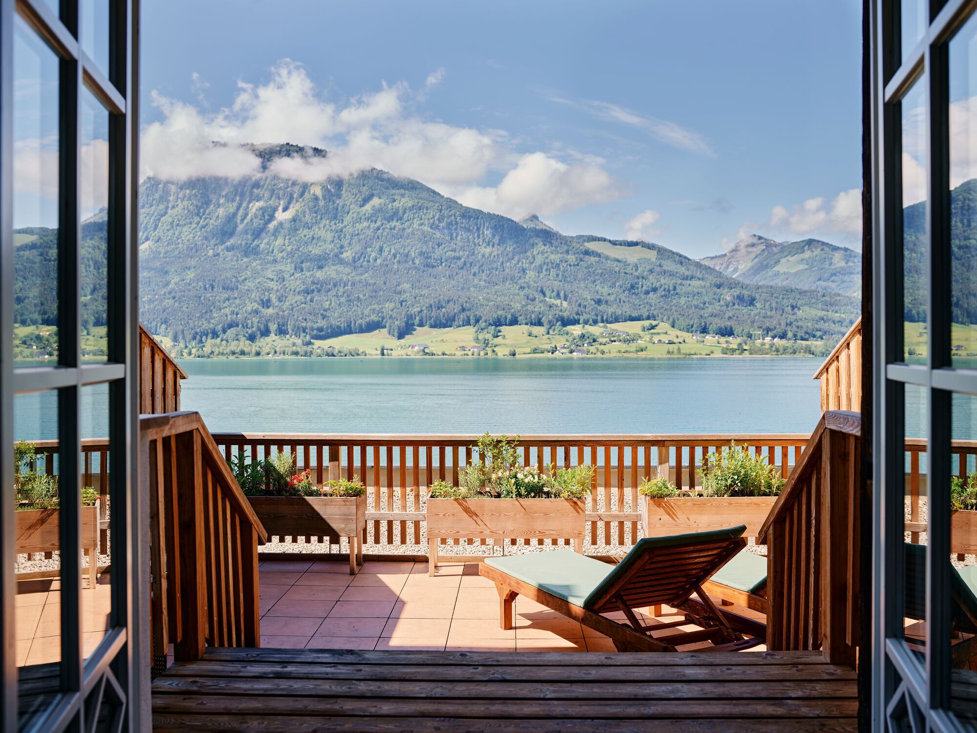 Eine Holzterrasse mit Blick auf einen See und Berge.