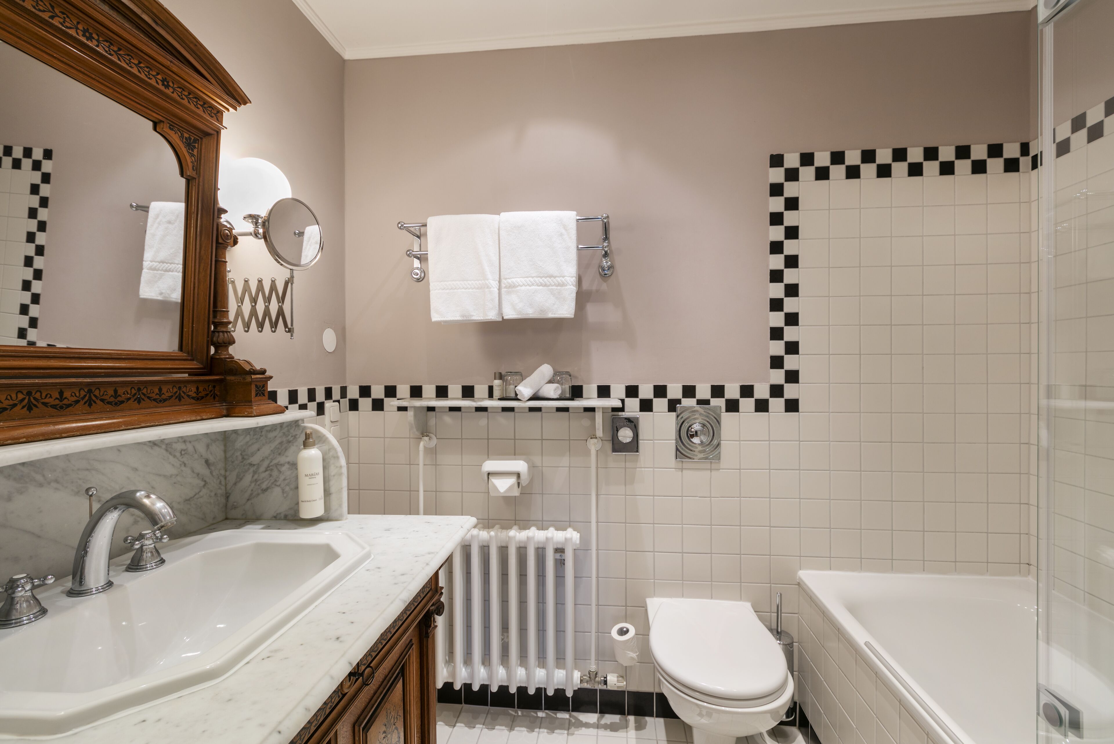 A bathroom with a marble sink, a toilet, and a bathtub.
