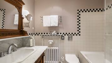A bathroom with a marble sink, a toilet, and a bathtub.