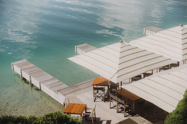 A resort with overwater bungalows, clear turquoise water, and a wooden deck.