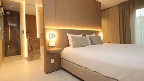 A modern hotel room with a large bed, wooden headboard, and bedside lamps.
