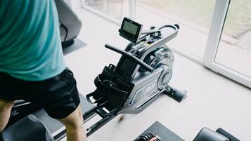 A stationary bike with a digital display, a weight stack, and a resistance knob.