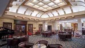 A grand lobby with a piano, multiple seating areas, and a high ceiling with skylights. - Barceló San Salvador (San Salvador)
