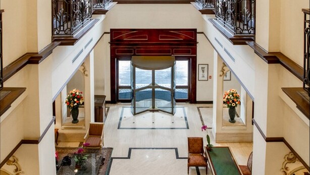 A grand lobby with a central staircase, a pool table, and a view of the sea through a large glass door. - Barceló San Salvador (San Salvador)