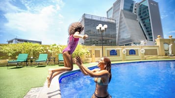 Una piscina al aire libre, sillones reclinables de piscina