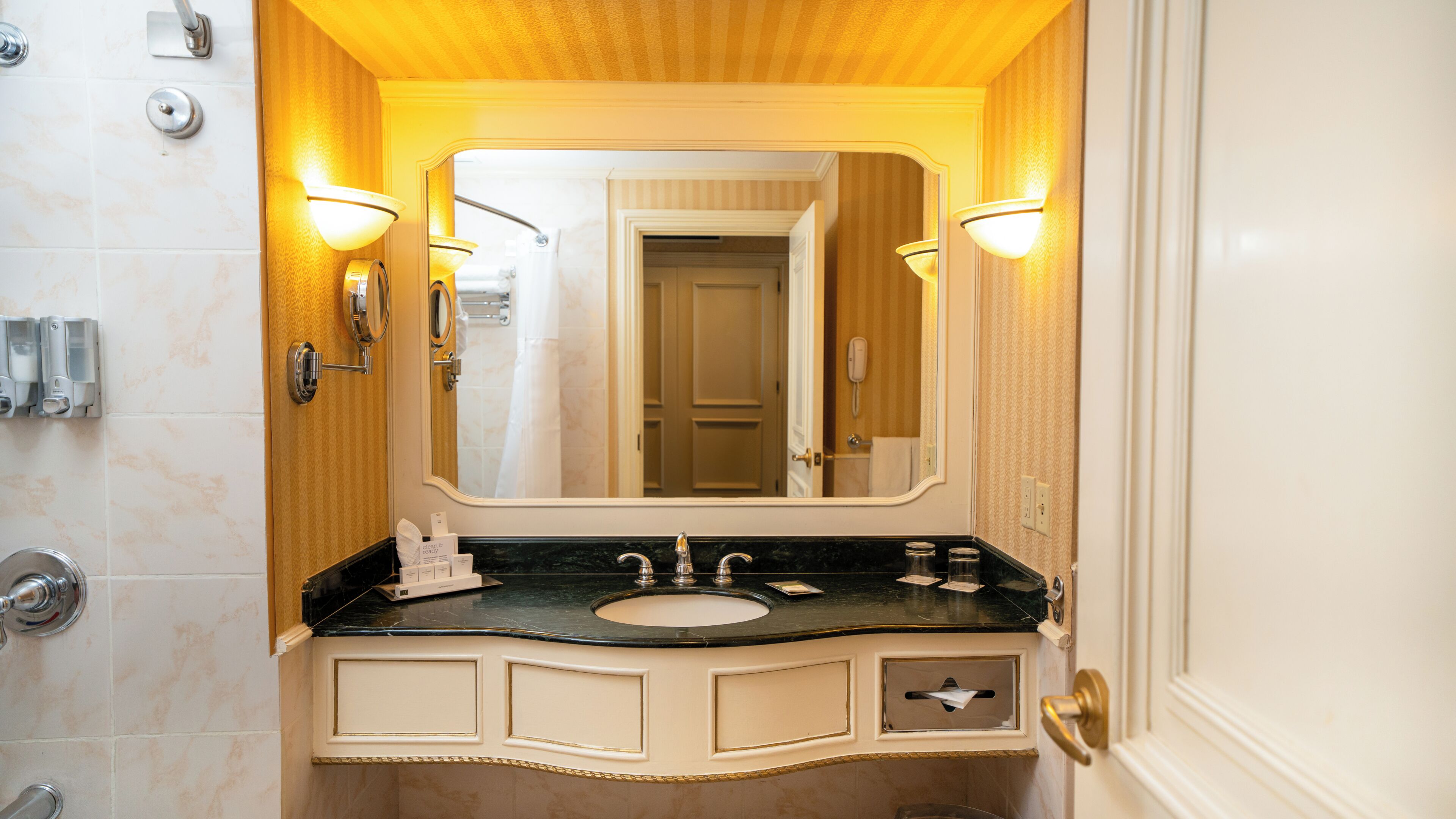 A bathroom with a sink, mirror, and towel rack.