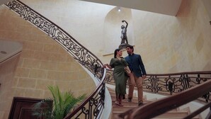 A staircase with ornate metal railings, a statue, and potted plants. - Barceló San Salvador (San Salvador)