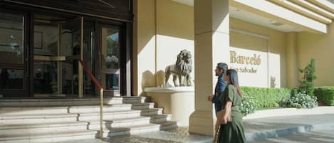 L'ingresso di un edificio con una statua di leone, una scalinata e un cartello che indica 'Barceló San Salvador'.