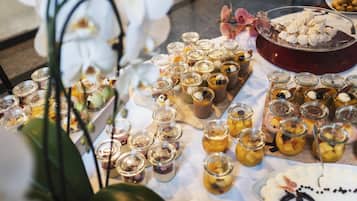 A table with various food items, including jars of preserves and desserts.
