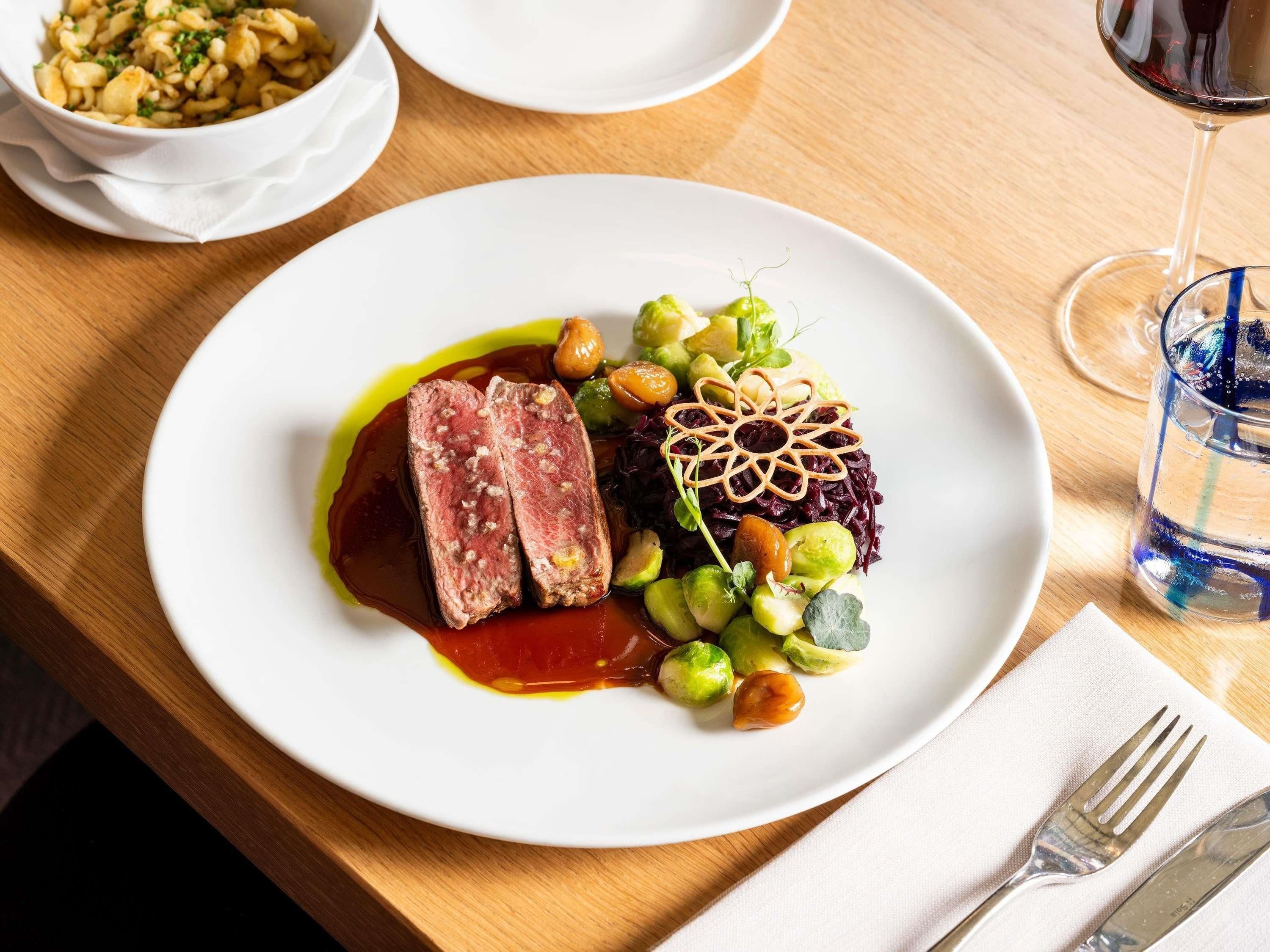 Une assiette de nourriture, un verre d’eau et une fourchette sur une table en bois.