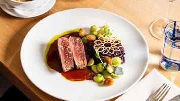 Une assiette de nourriture, un verre d’eau et une fourchette sur une table en bois.