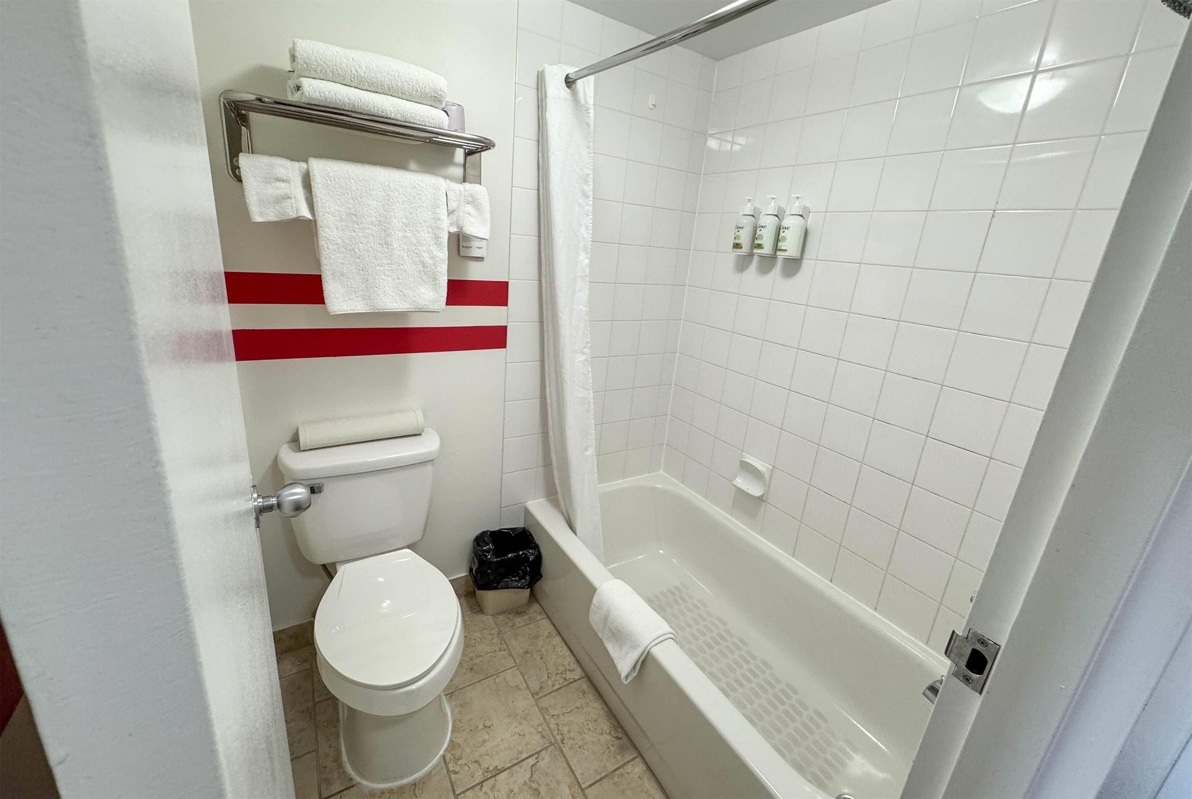 Une salle de bain équipée de toilettes, d’une baignoire et d’une douche.