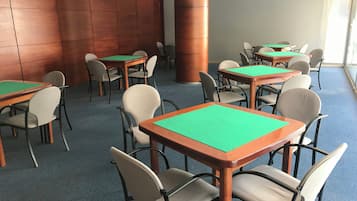 Una sala conferenze con diversi tavoli e sedie, un'imponente colonna e un pavimento rivestito di moquette blu.