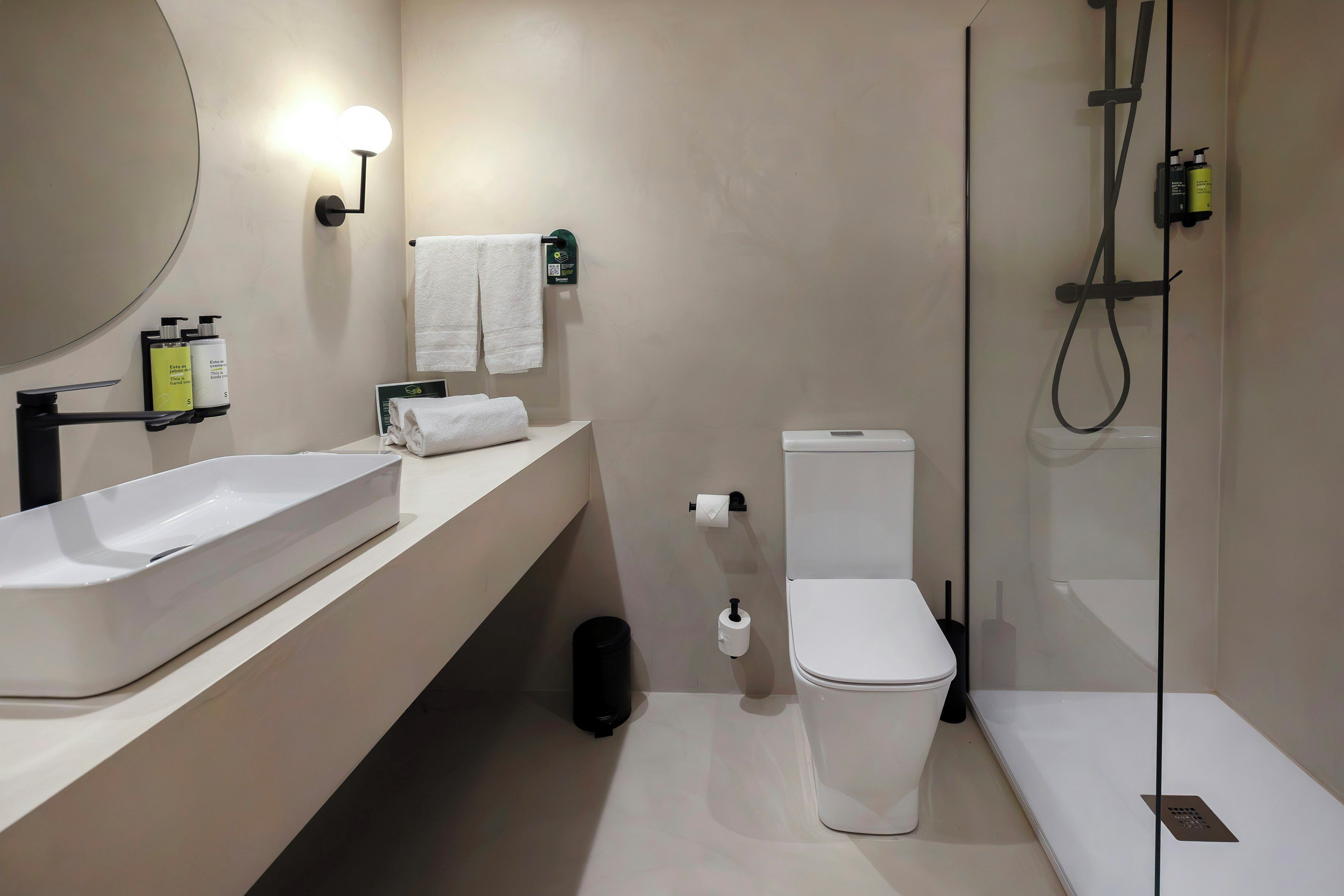 A modern bathroom with a large sink, toilet, and shower.