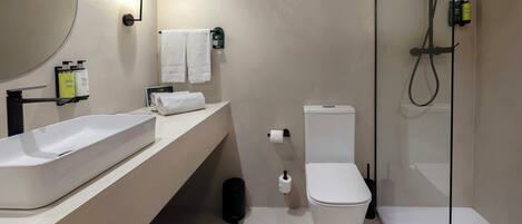 A modern bathroom with a large sink, toilet, and shower.
