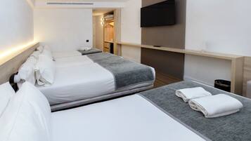 A hotel room with two beds, a TV mounted on the wall, and a walk-in closet.