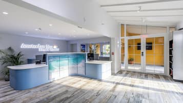 A reception area with a curved blue counter, a large window with a view, and a wooden floor.