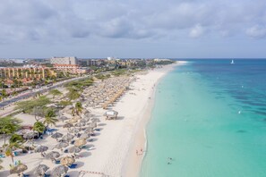 Am Strand, weißer Sandstrand, Liegestühle, Sonnenschirme