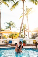 Una piscina al aire libre, sombrillas, sillones reclinables de piscina